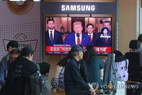 22일 서울역 대합실에서 시민들이 이란 공습 관련 미국 트럼프 대통령의 대국민 연설 방송을 시청하고 있다.   [연합뉴스]